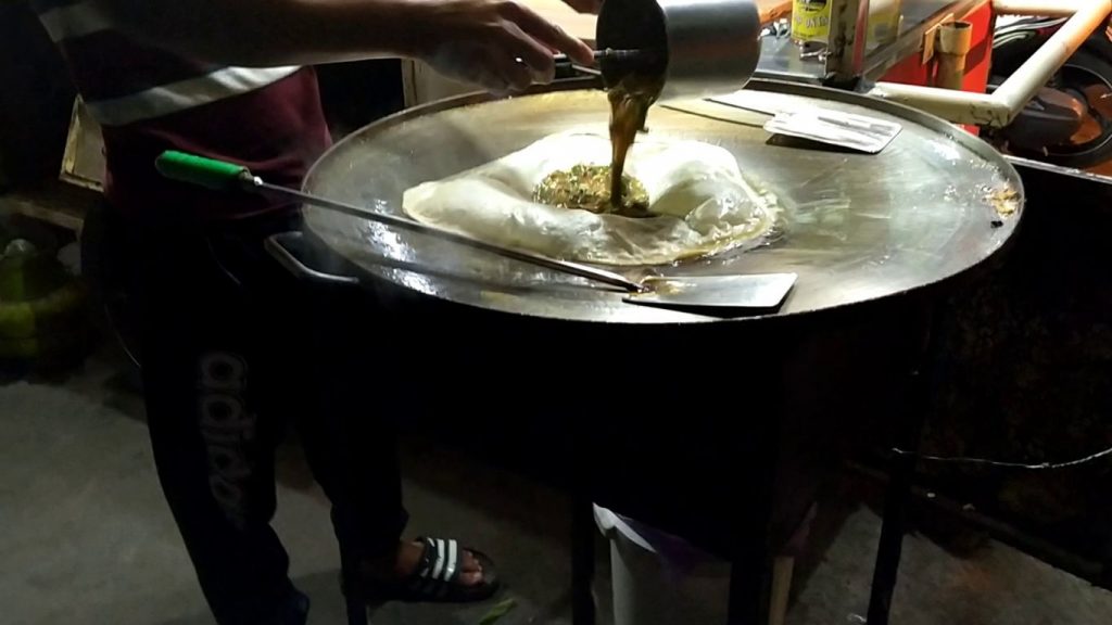 adding martabak filling on the dough